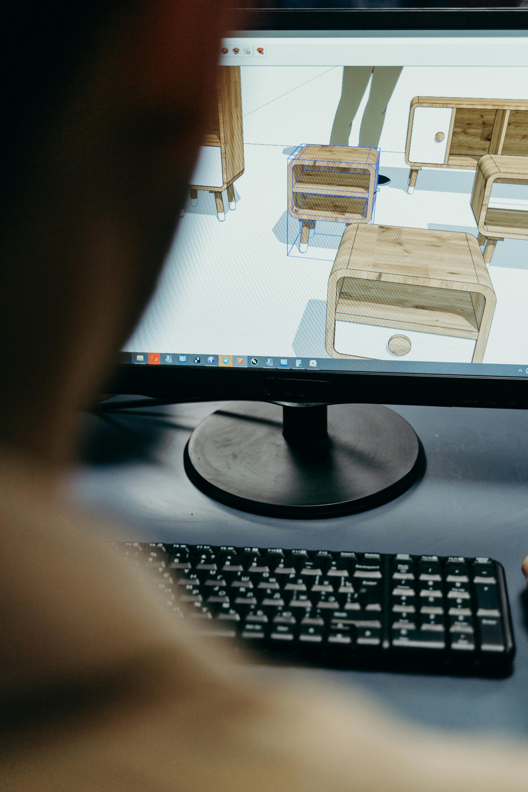 Close-up of digital furniture design on a computer monitor in an office setting.